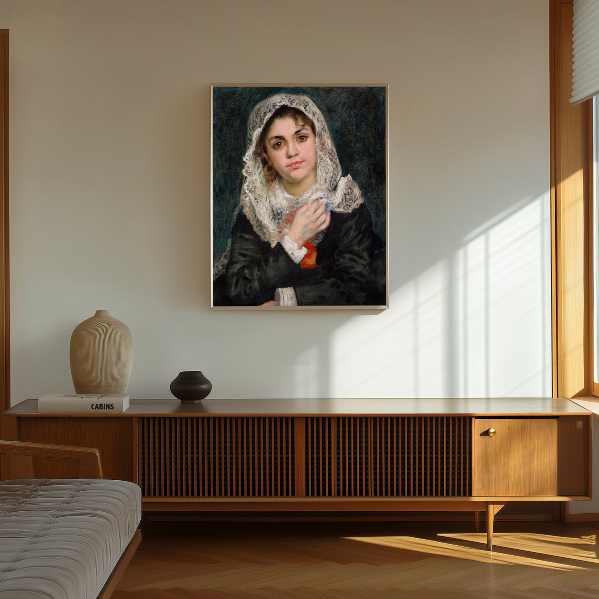 Framed art print of Lise in a White Shawl by Pierre-Auguste Renoir, in a thin light frame on a sunlit wall above a wooden sideboard