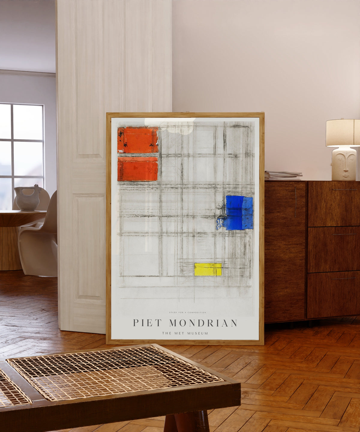 Framed art print of Study for a Composition by Piet Mondrian, in a light wood frame leaning in a warm room with a parquet floor