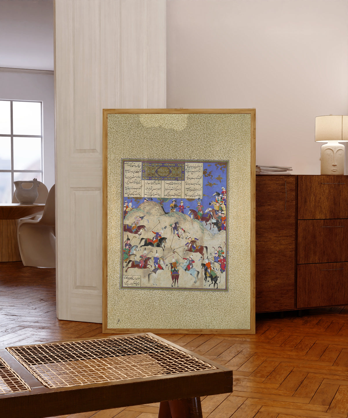 Framed art print of Shahnama of Shah Tahmasp: Siyavush Plays… by Qasim ibn Ali (attributed), in a light wood frame leaning in a warm room with a parquet floor