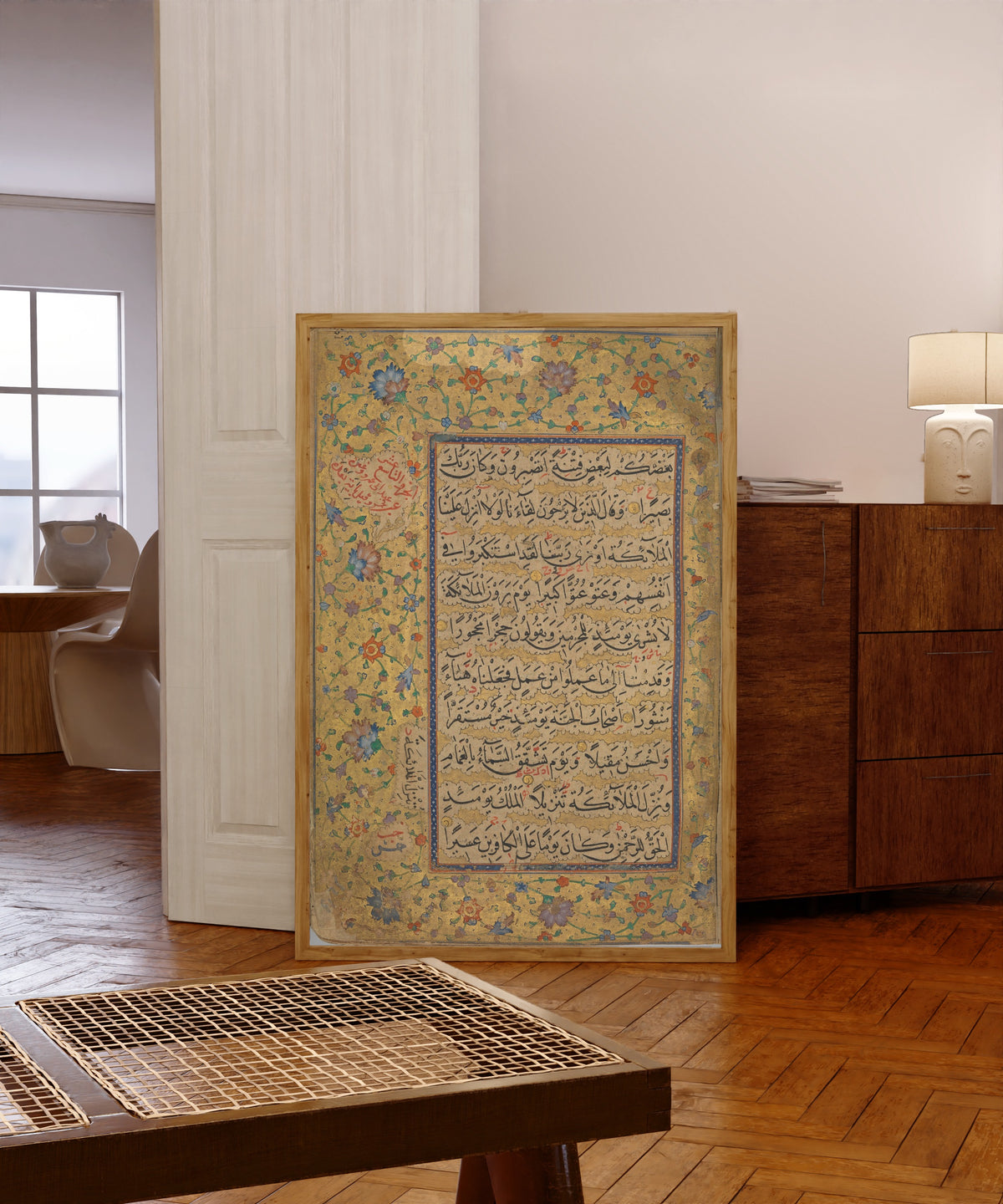 Framed art print of Quran Folio by Ibrahim Sultan (Timurid), in a light wood frame leaning in a warm room with a parquet floor