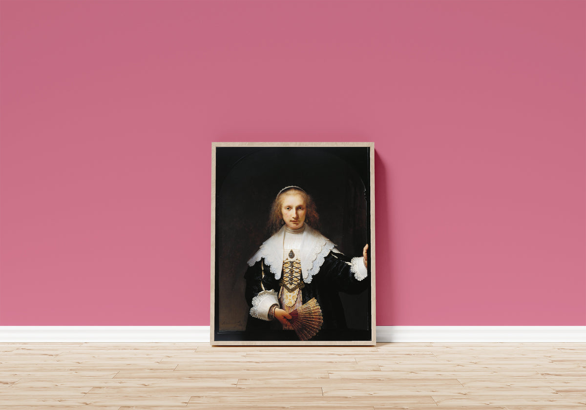 Framed art print of Agatha Bas (1611–1658) by Rembrandt van Rijn, in a light wood frame leaning on a pink wall above a wooden floor