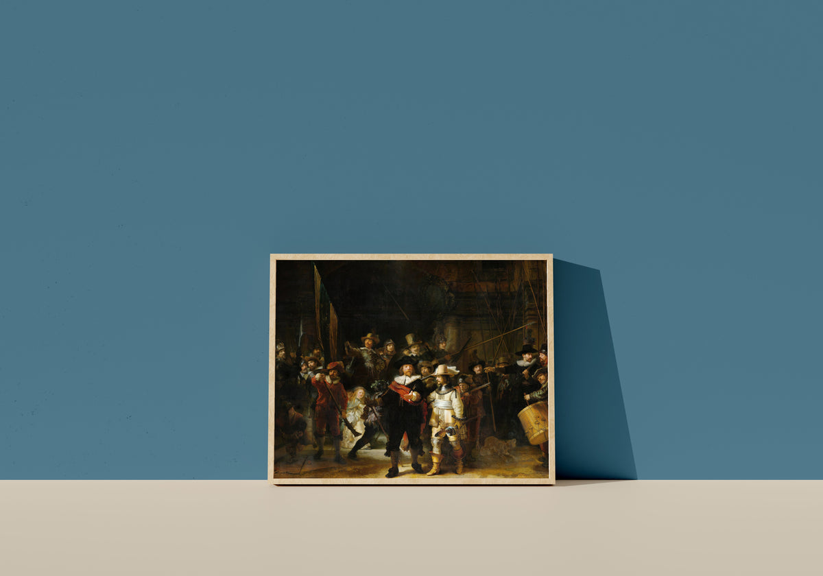 Framed art print of The Night Watch, Militia Company of District II under the Command of… by Rembrandt van Rijn, in a light wood frame leaning on a blue wall