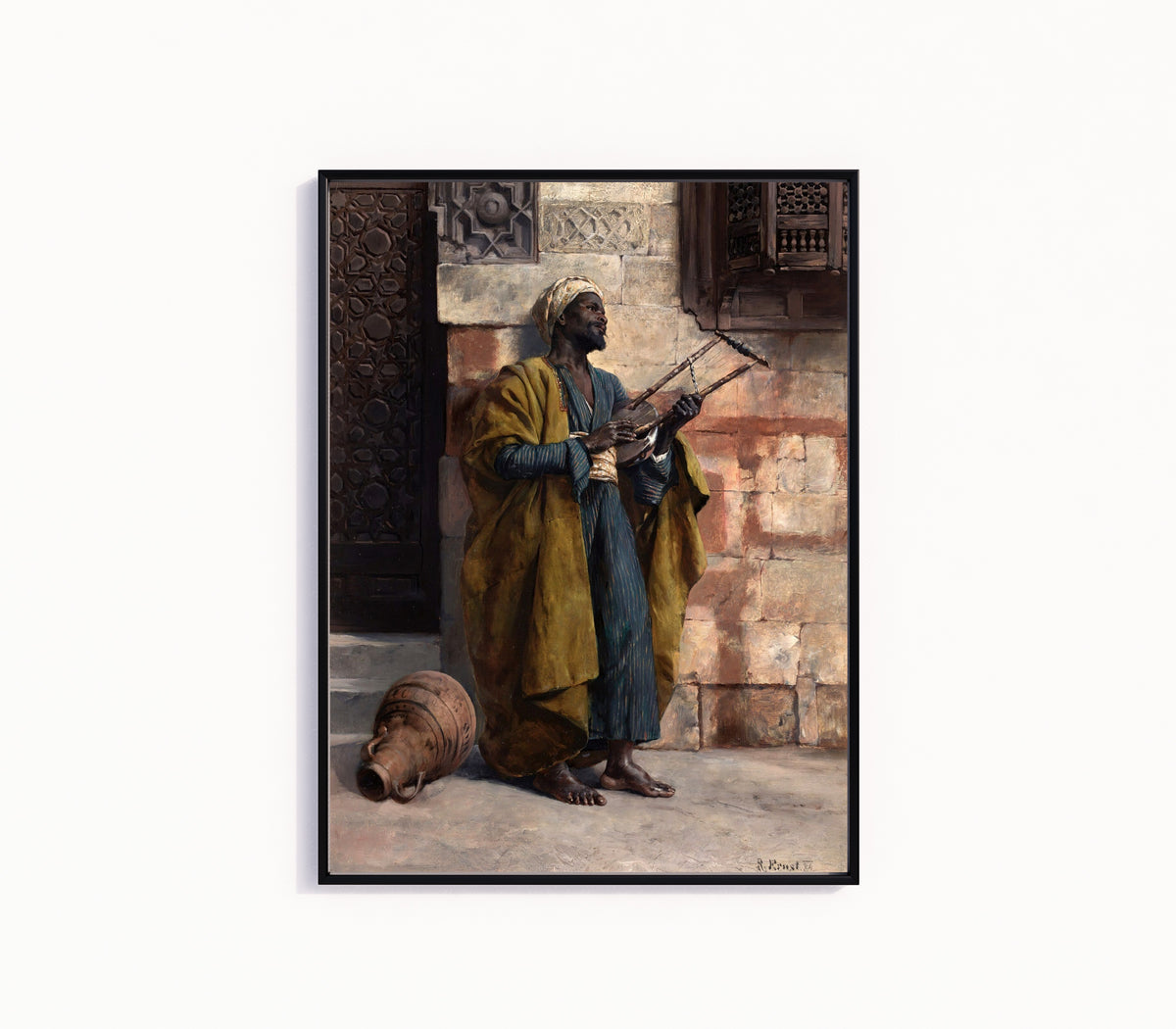 Framed art print of The Musician by Rudolf Ernst, in a slim black frame on a plain white wall