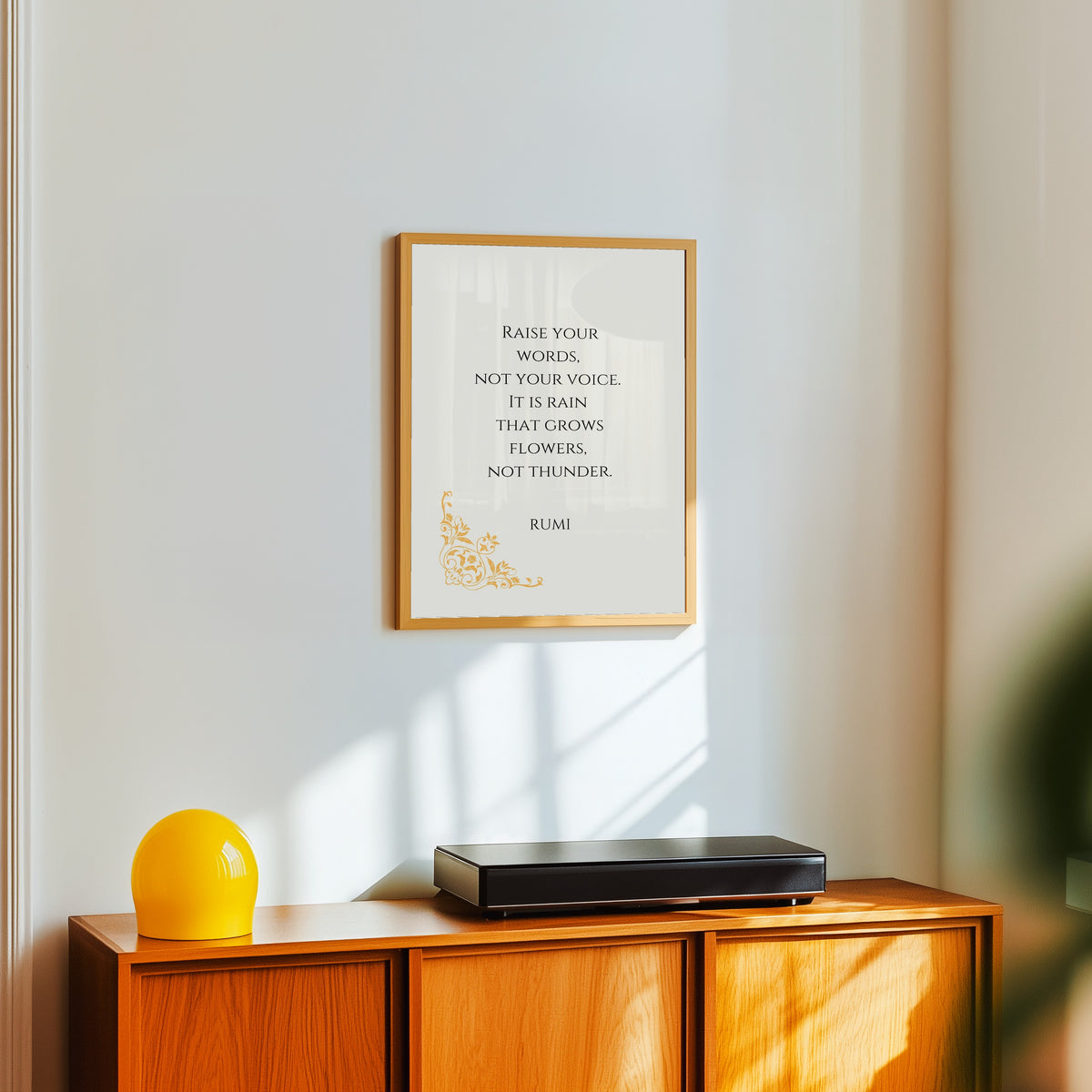 Framed art print of Rain and Thunder by Rumi, in a light wood frame on a white wall above an orange sideboard