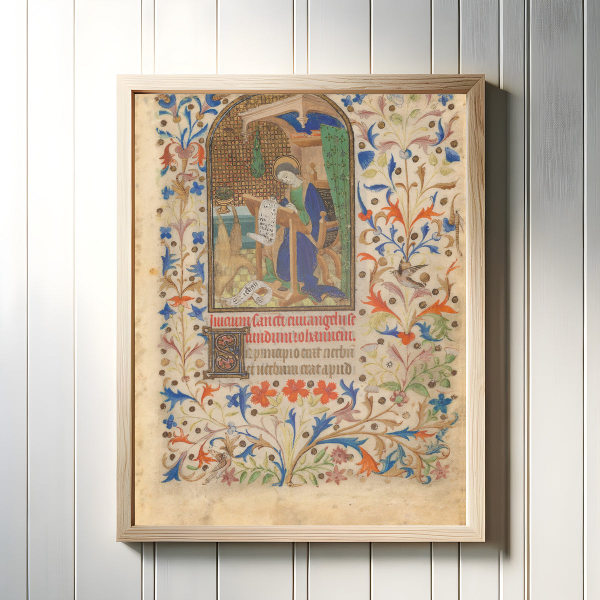 Framed art print of Saint John, in a light wood frame on a white panelled wall
