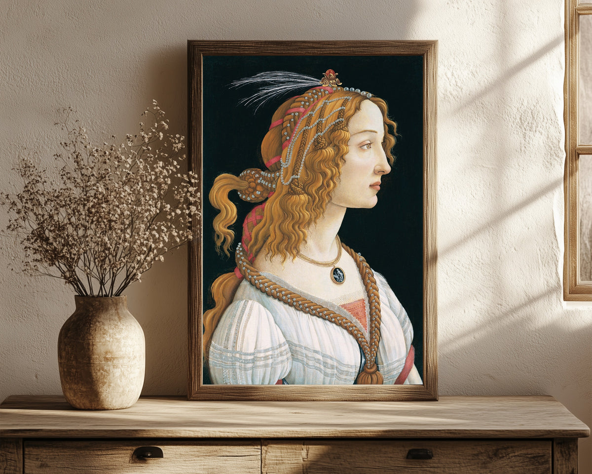 Framed art print of Idealized Portrait of a Lady by Sandro Botticelli, in a dark wood frame leaning on a rustic console beside dried flowers