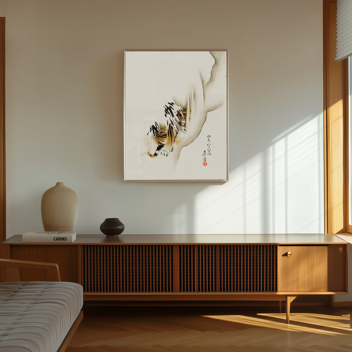 Framed art print of Tiger by Shibata Zeshin, in a thin light frame on a sunlit wall above a wooden sideboard