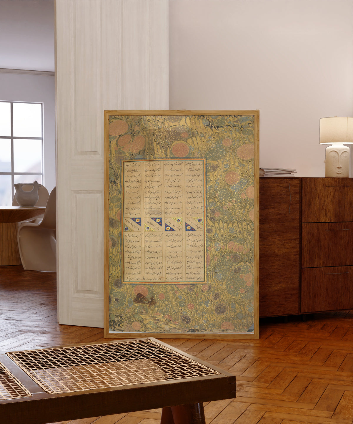 Framed art print of Page of Calligraphy from a Mantiq al-Tayr… by Sultan 'Ali al-Mashhadi, in a light wood frame leaning in a warm room with a parquet floor