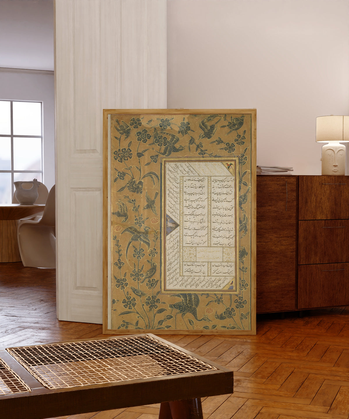 Framed art print of Page of Calligraphy with Stenciled and… by Sultan 'Ali al-Mashhadi, in a light wood frame leaning in a warm room with a parquet floor