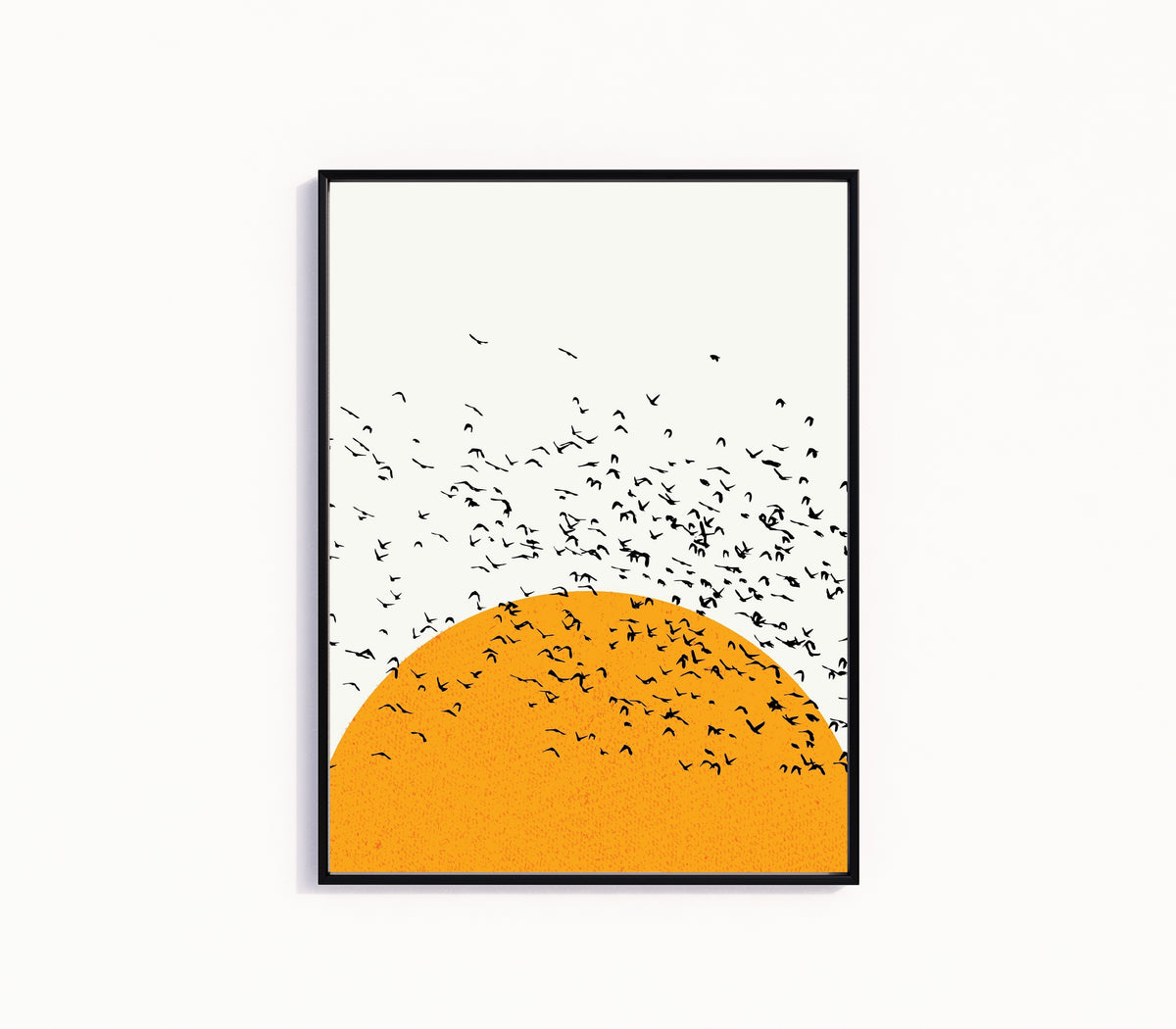 Framed art print of Sunset and Birds by Bauhaus, in a slim black frame on a plain white wall