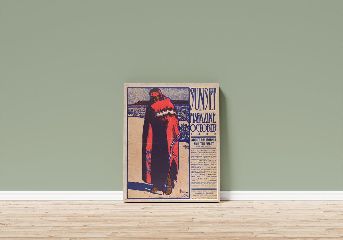 Framed art print of Sunset Magazine (October 1902) by Maynard Dixon, in a light wood frame leaning on a sage green wall above a wooden floor