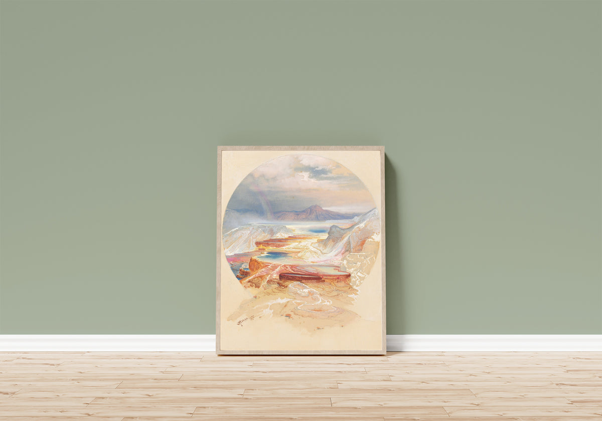 Framed art print of Minerva Terrace, Yellowstone by Thomas Moran, in a light wood frame leaning on a sage green wall above a wooden floor