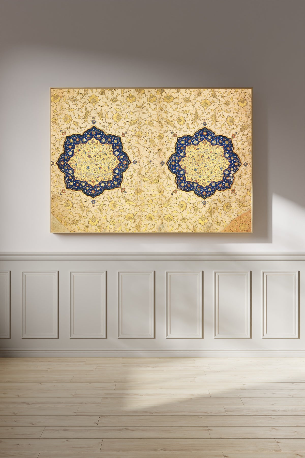 Illuminated Qur'an Opening by Ibrahim Sultan — framed on a panelled wall in afternoon light