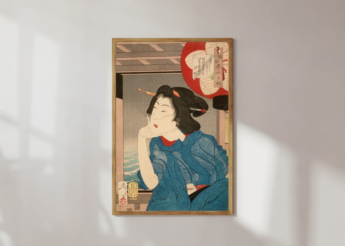 Framed art print of A Geisha of the Mid-1870s Seated in a Boat by Tsukioka Yoshitoshi, in a light wood frame on a sunlit white wall