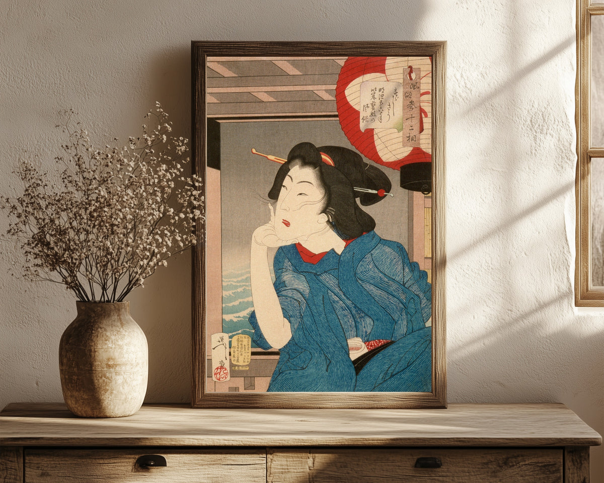 Framed art print of A Geisha of the Mid-1870s Seated in a Boat by Tsukioka Yoshitoshi, in a dark wood frame leaning on a rustic console beside dried flowers