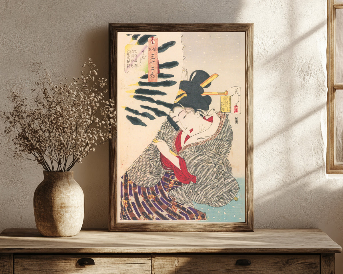 Framed art print of Fūzoku sanjūni sō: Looks Cold (Tenpō-era… by Tsukioka Yoshitoshi, in a dark wood frame leaning on a rustic console beside dried flowers