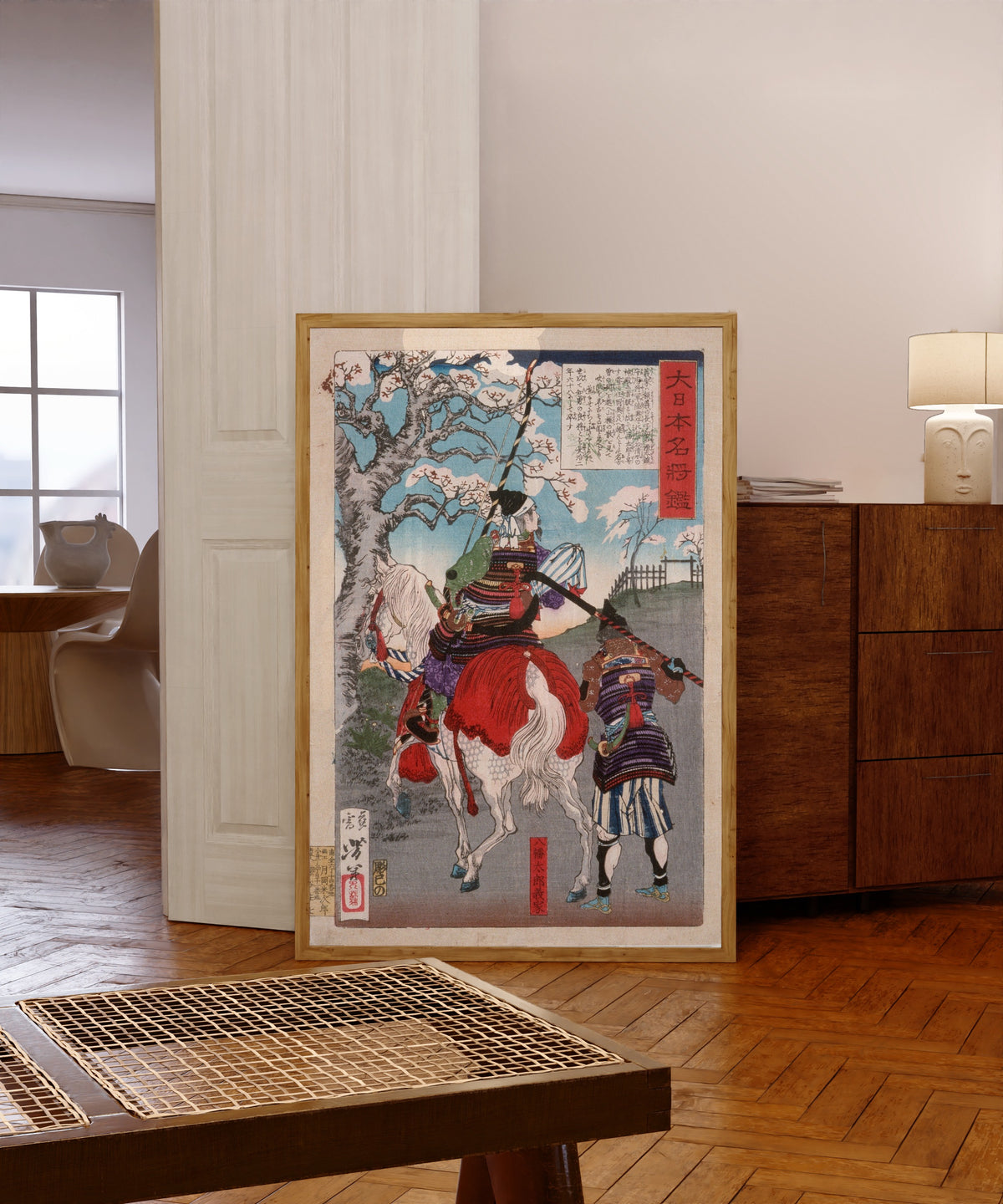 Framed art print of Hachimantarō Yoshiie at Nakoso Barrier by Tsukioka Yoshitoshi, in a light wood frame leaning in a warm room with a parquet floor