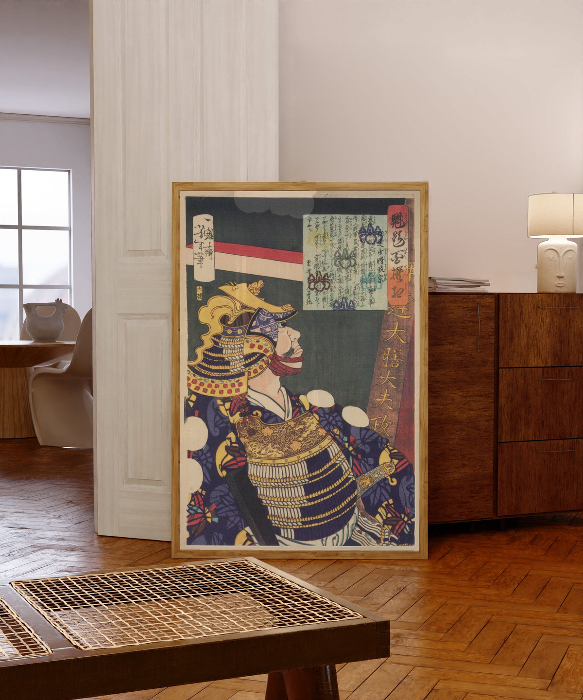 Framed art print of Kaidai hyakusensō: Date Shōshō Masamune by Tsukioka Yoshitoshi, in a light wood frame leaning in a warm room with a parquet floor