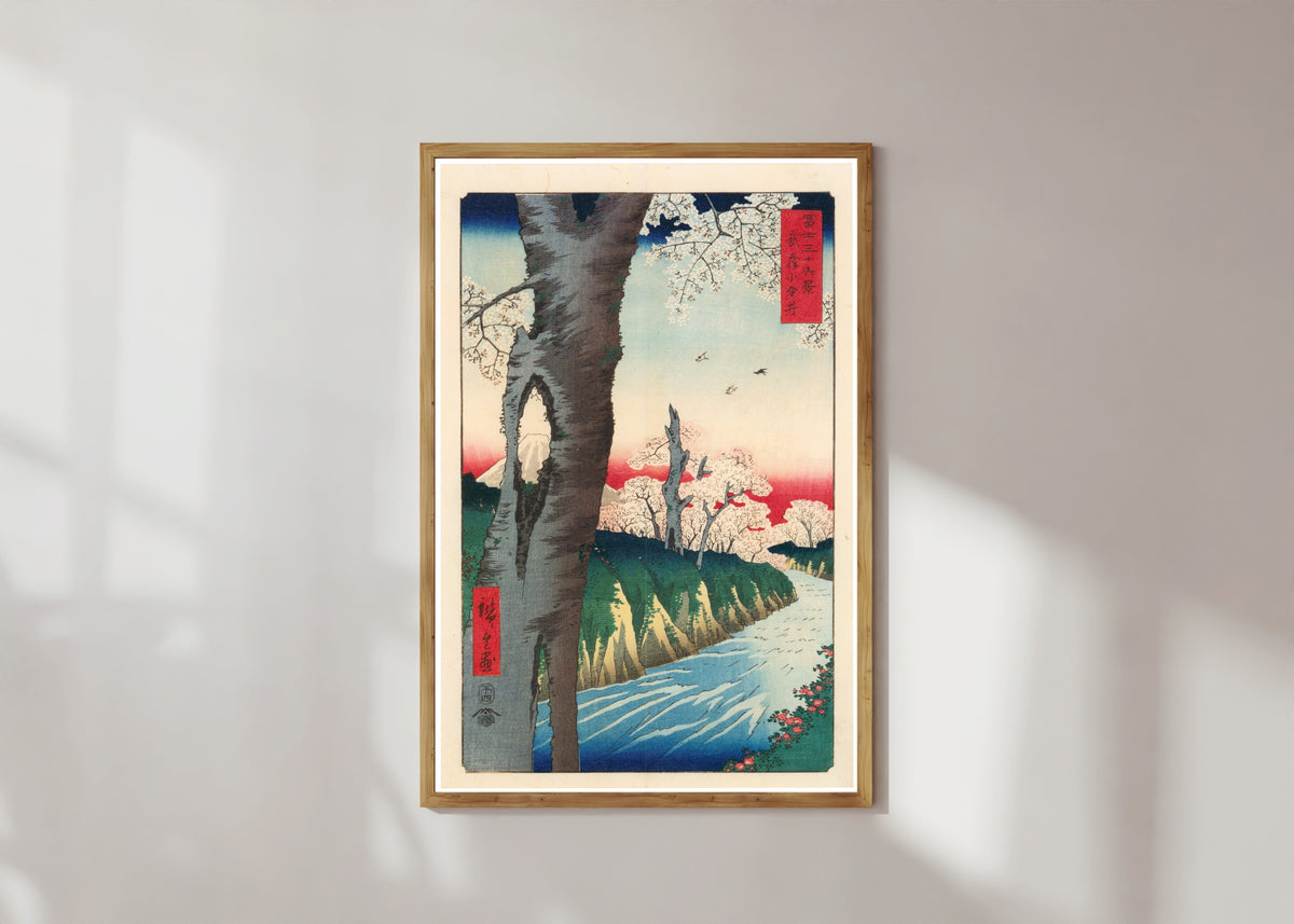 Framed art print of Koganei in Musashi Province by Utagawa Hiroshige, in a light wood frame on a sunlit white wall