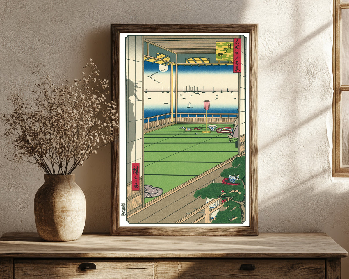 Framed art print of Moon Viewing by Utagawa Hiroshige, in a dark wood frame leaning on a rustic console beside dried flowers