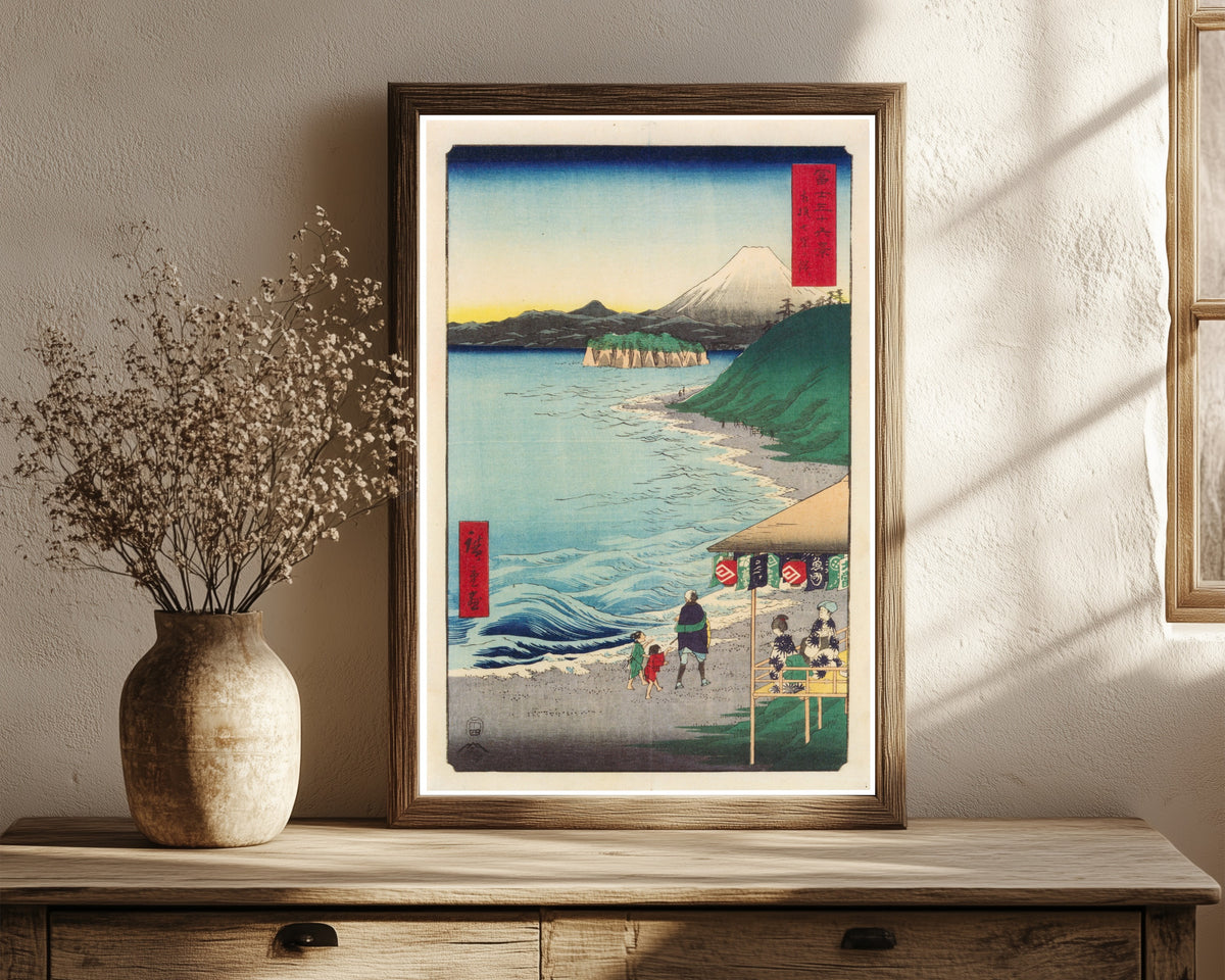 Framed art print of The Seven Ri Beach in Sagami Province by Utagawa Hiroshige, in a dark wood frame leaning on a rustic console beside dried flowers