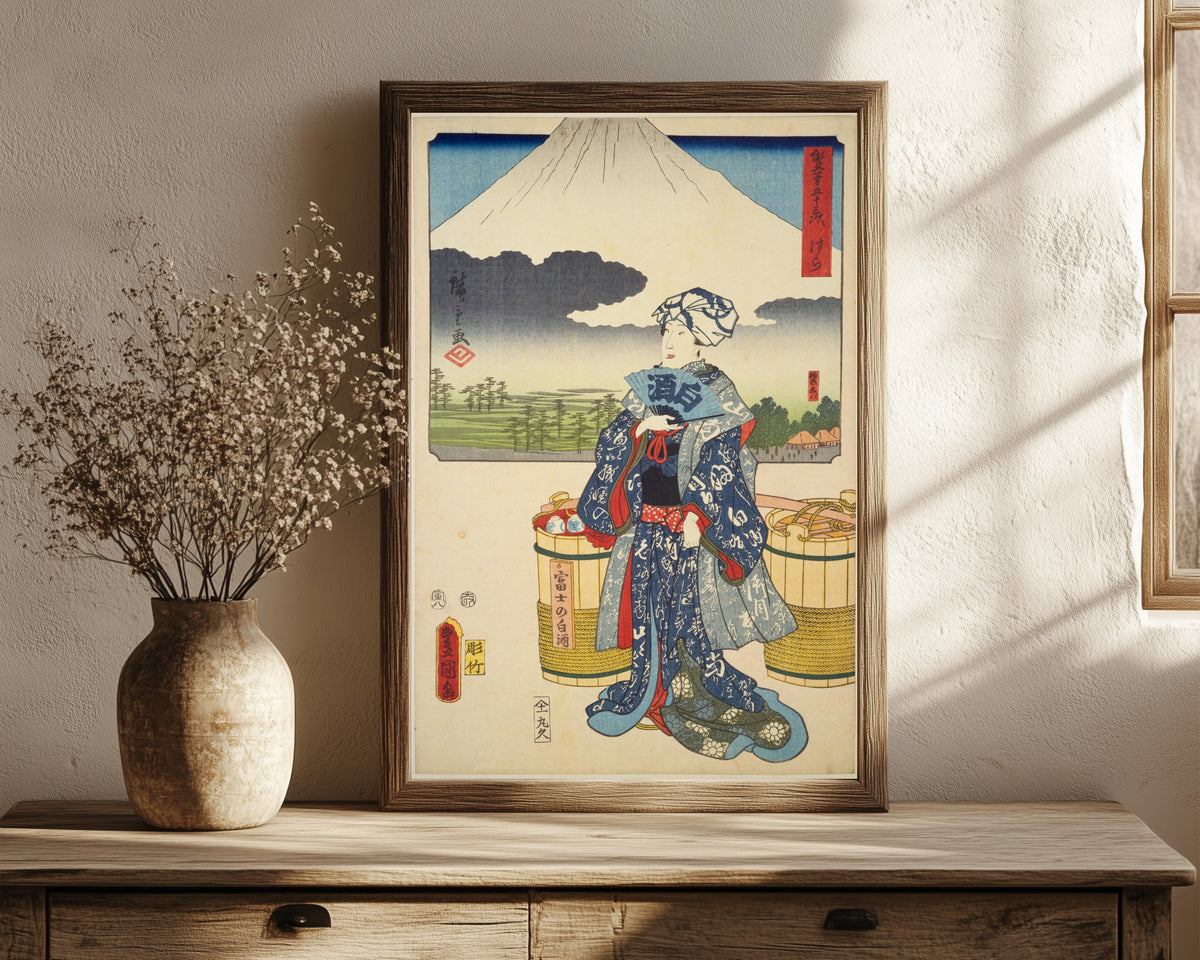 Framed art print of Fifty-three Stations by Two… by Utagawa Hiroshige & Utagawa Kunisada, in a dark wood frame leaning on a rustic console beside dried flowers