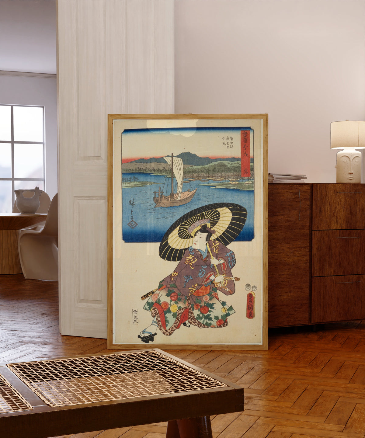 Framed art print of Fifty-three Stations by Two… by Utagawa Hiroshige & Utagawa Kunisada, in a light wood frame leaning in a warm room with a parquet floor