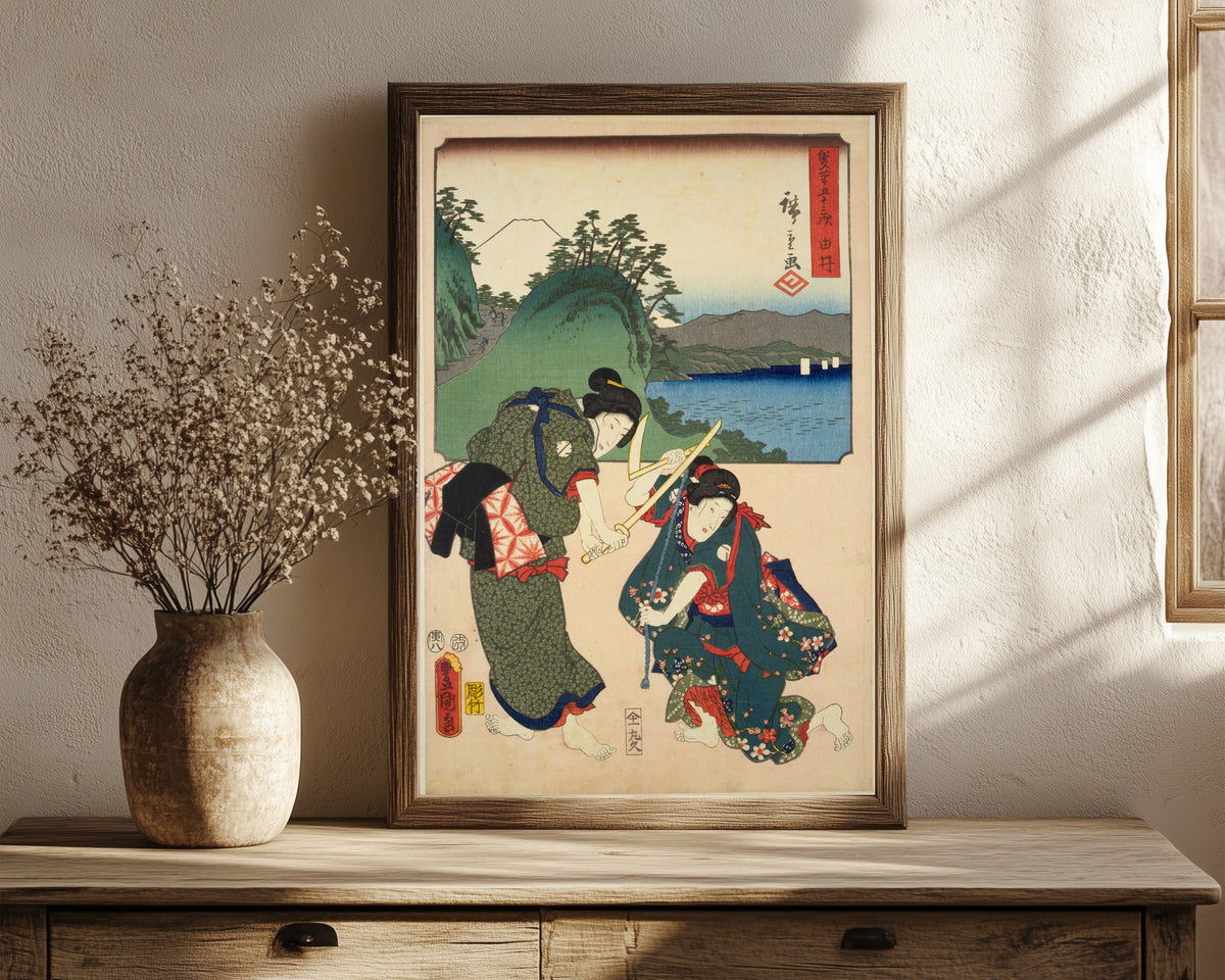 Framed art print of Fifty-three Stations by Two… by Utagawa Hiroshige & Utagawa Kunisada, in a dark wood frame leaning on a rustic console beside dried flowers