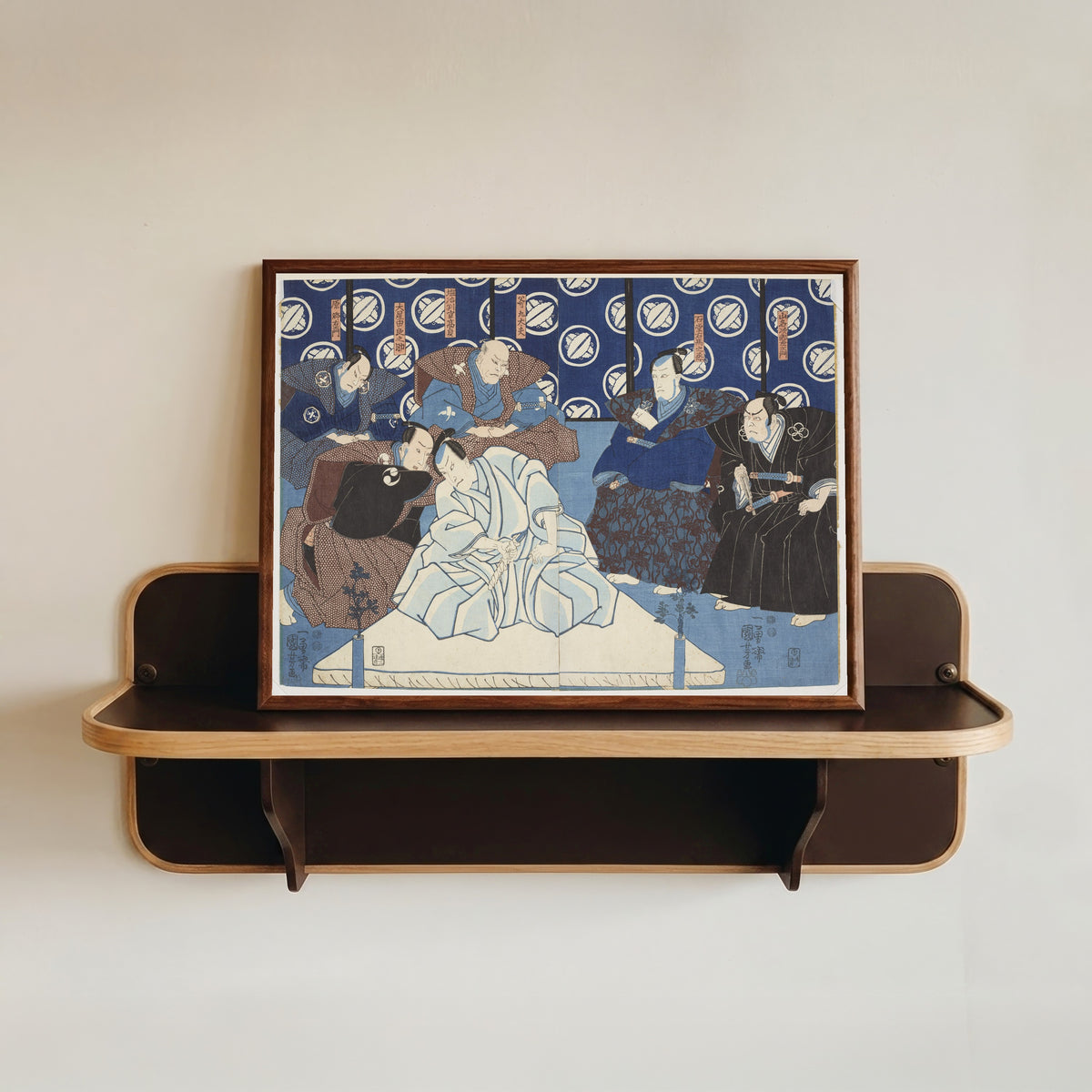 Framed art print of Kanadehon Chūshingura, Act 4: Seppuku of Lord En'ya by Utagawa Kuniyoshi, in a dark wood frame resting on a wall shelf