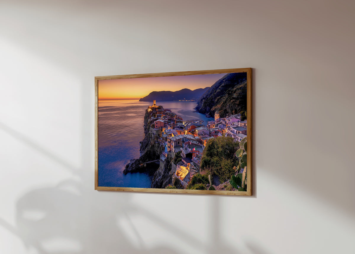 Framed art print of Vernazza Sunset by Pablo Meilán Campagnale, in a light wood frame on a sunlit white wall, seen at a slight angle