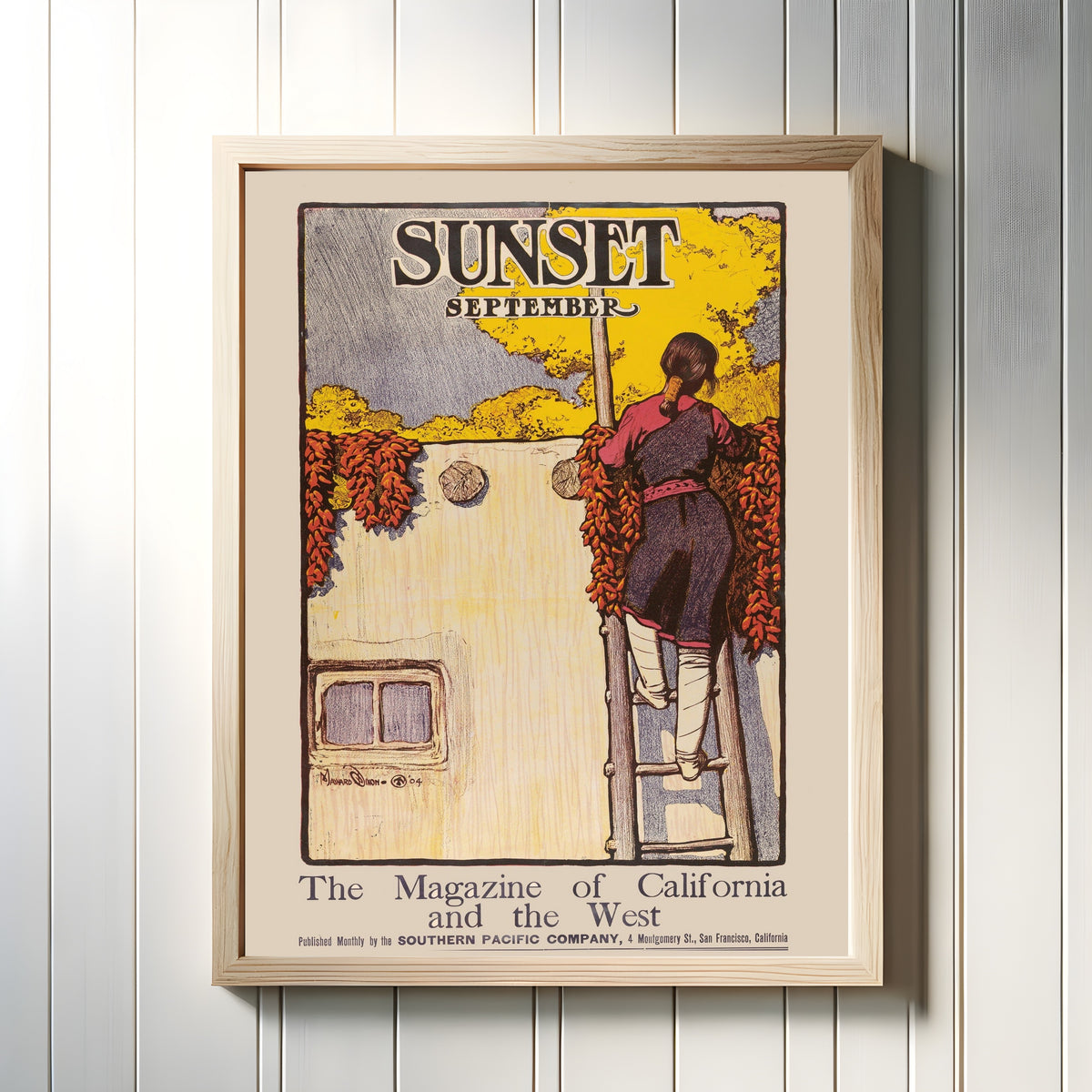 Framed art print of California Adobe by Maynard Dixon, in a light wood frame on a white panelled wall