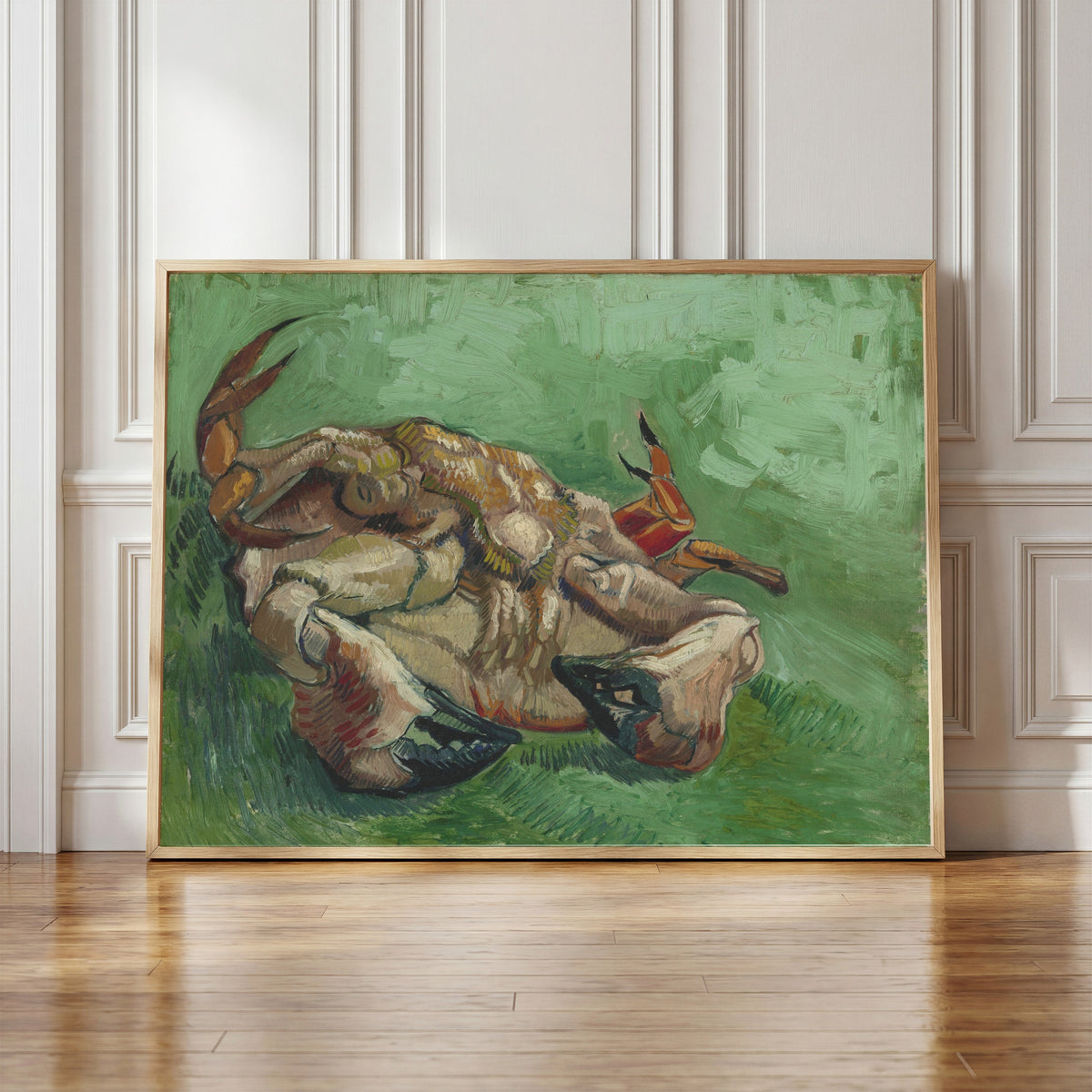 Framed art print of A Crab on its Back by Vincent van Gogh, in a light wood frame leaning against a panelled white wall