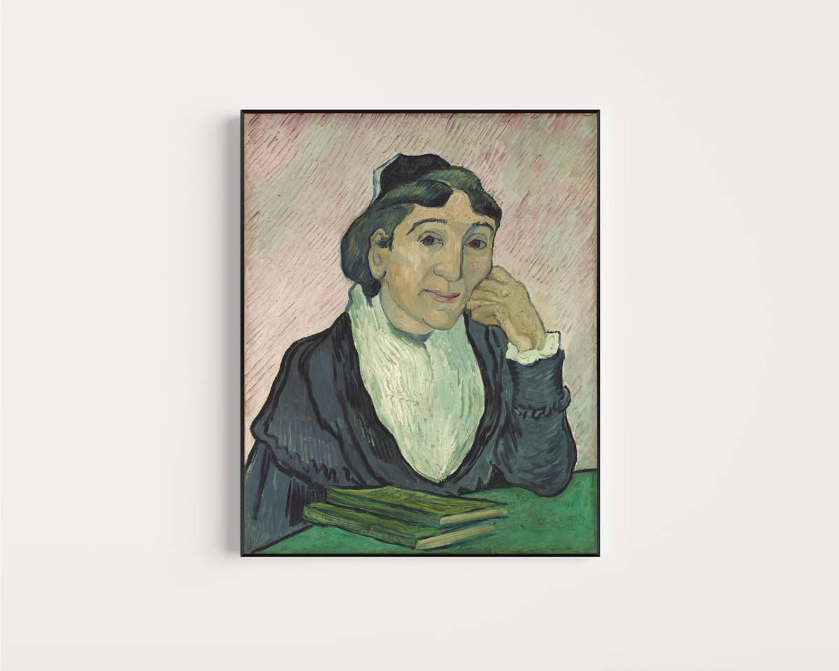Framed art print of L'Arlésienne (Madame Ginoux) by Vincent van Gogh, in a slim black frame on a plain white wall