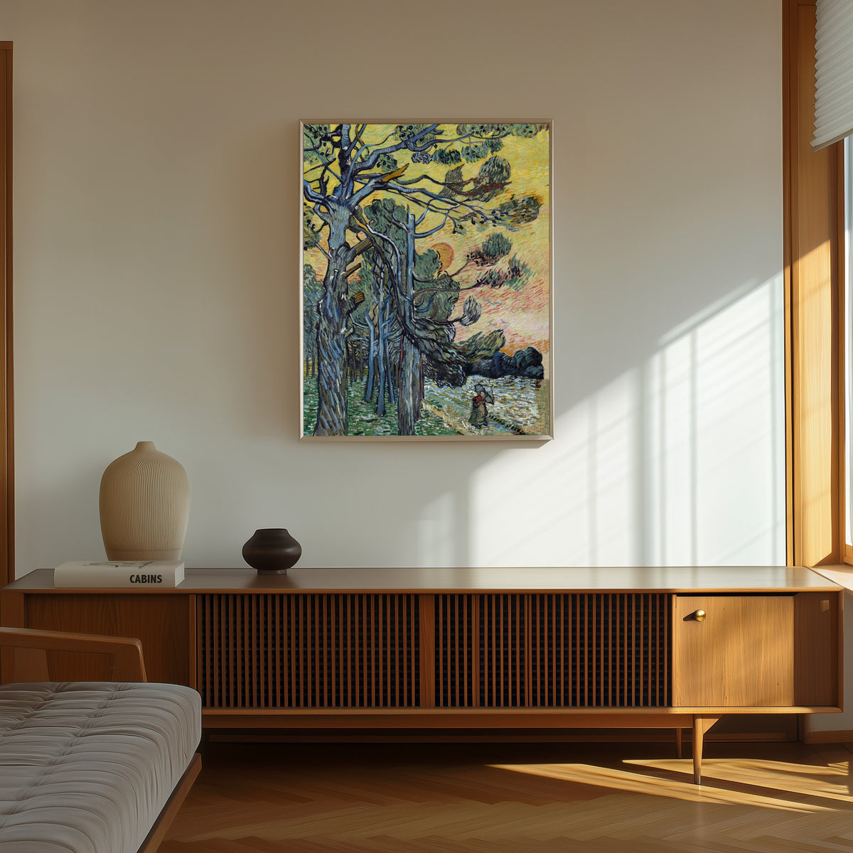 Framed art print of Pine Trees at Sunset by Vincent van Gogh, in a thin light frame on a sunlit wall above a wooden sideboard