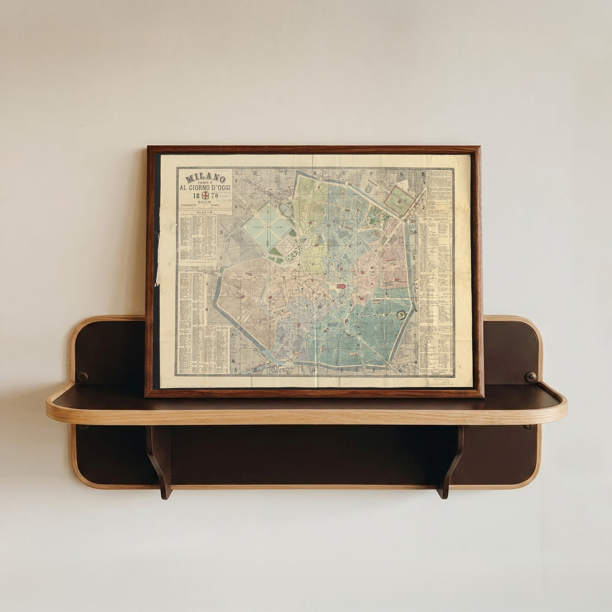 Framed art print of Milano come è al giorno d'oggi (1870), in a dark wood frame resting on a wall shelf