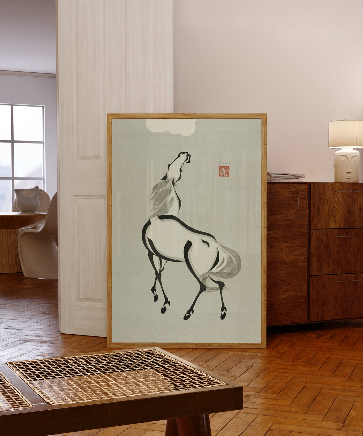Framed art print of Horse with Raised Head by Wakyosai, in a light wood frame leaning in a warm room with a parquet floor