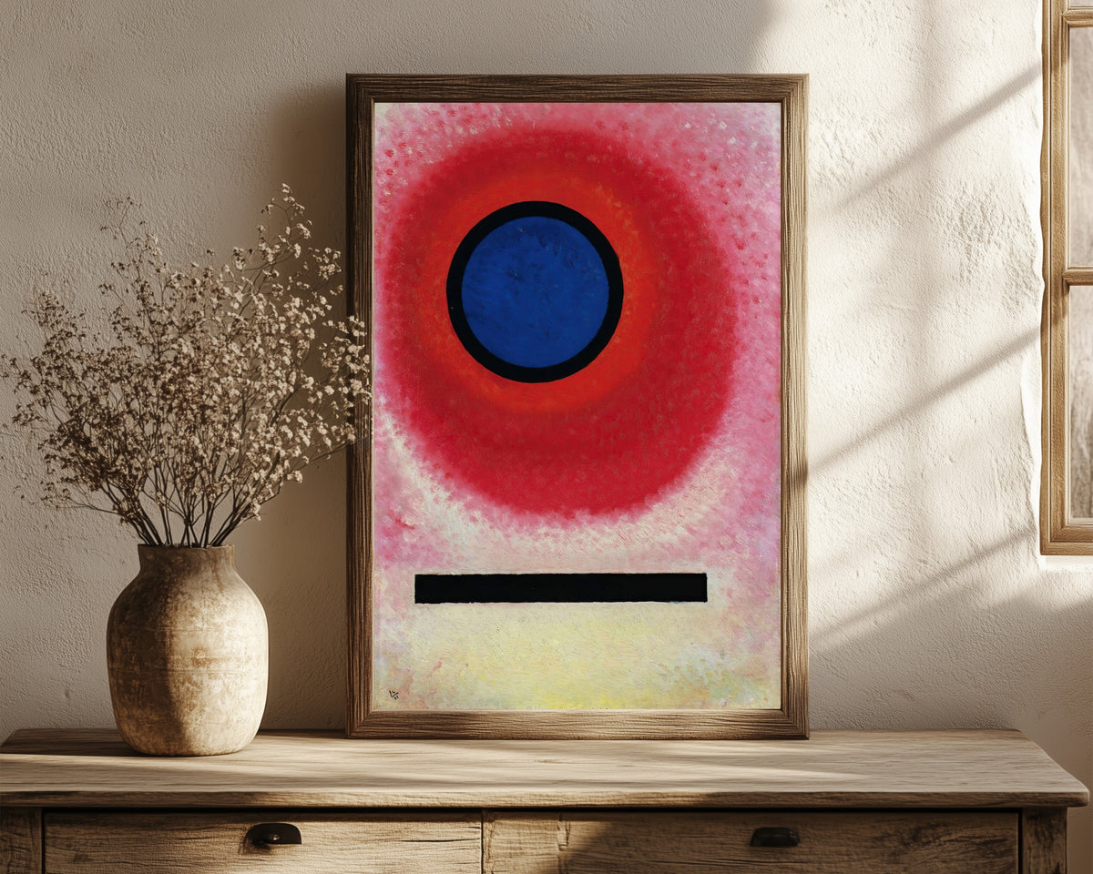 Framed art print of Blue Circle 2 by Wassily Kandinsky, in a dark wood frame leaning on a rustic console beside dried flowers