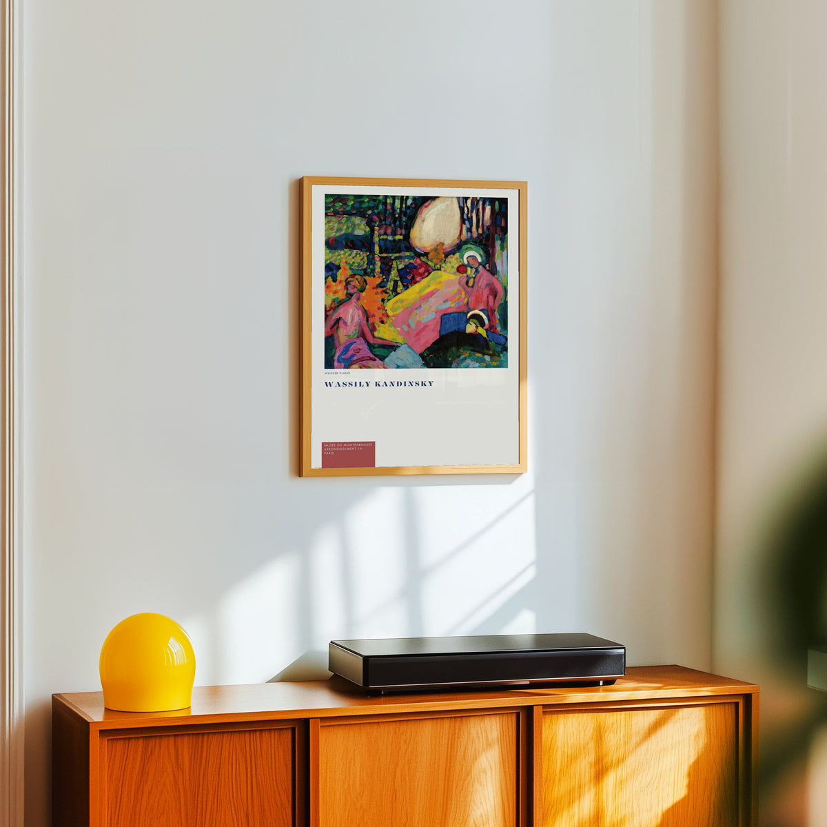 Framed art print of White Sound (Weisser Klang) by Wassily Kandinsky, in a light wood frame on a white wall above an orange sideboard