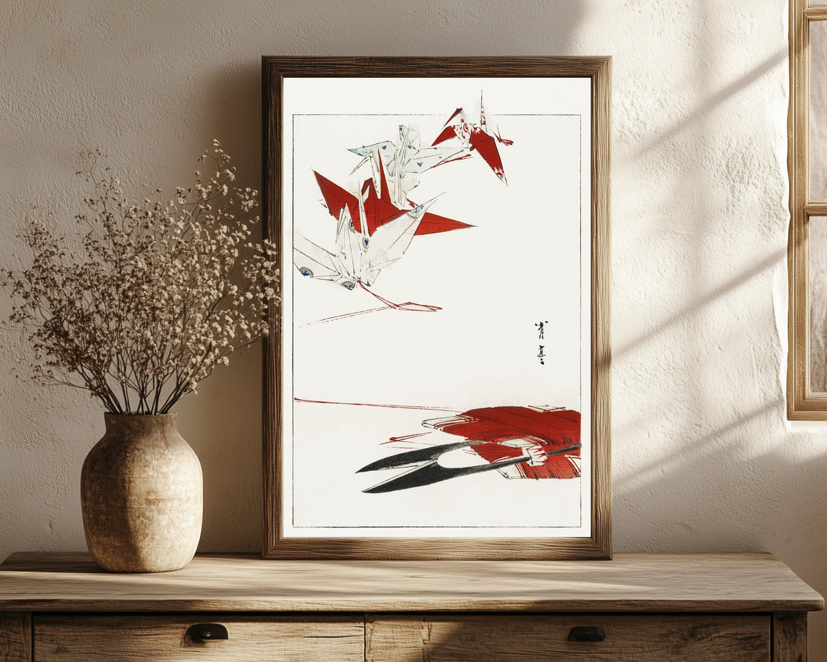Framed art print of Bird Origami by Watanabe Seitei, in a dark wood frame leaning on a rustic console beside dried flowers