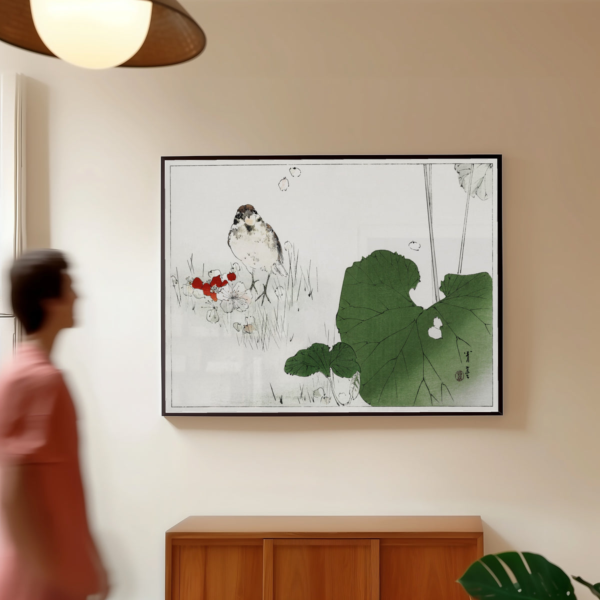 Framed art print of Eurasian tree sparrow by Watanabe Seitei, in a slim black frame on a warm wall in a sunlit room