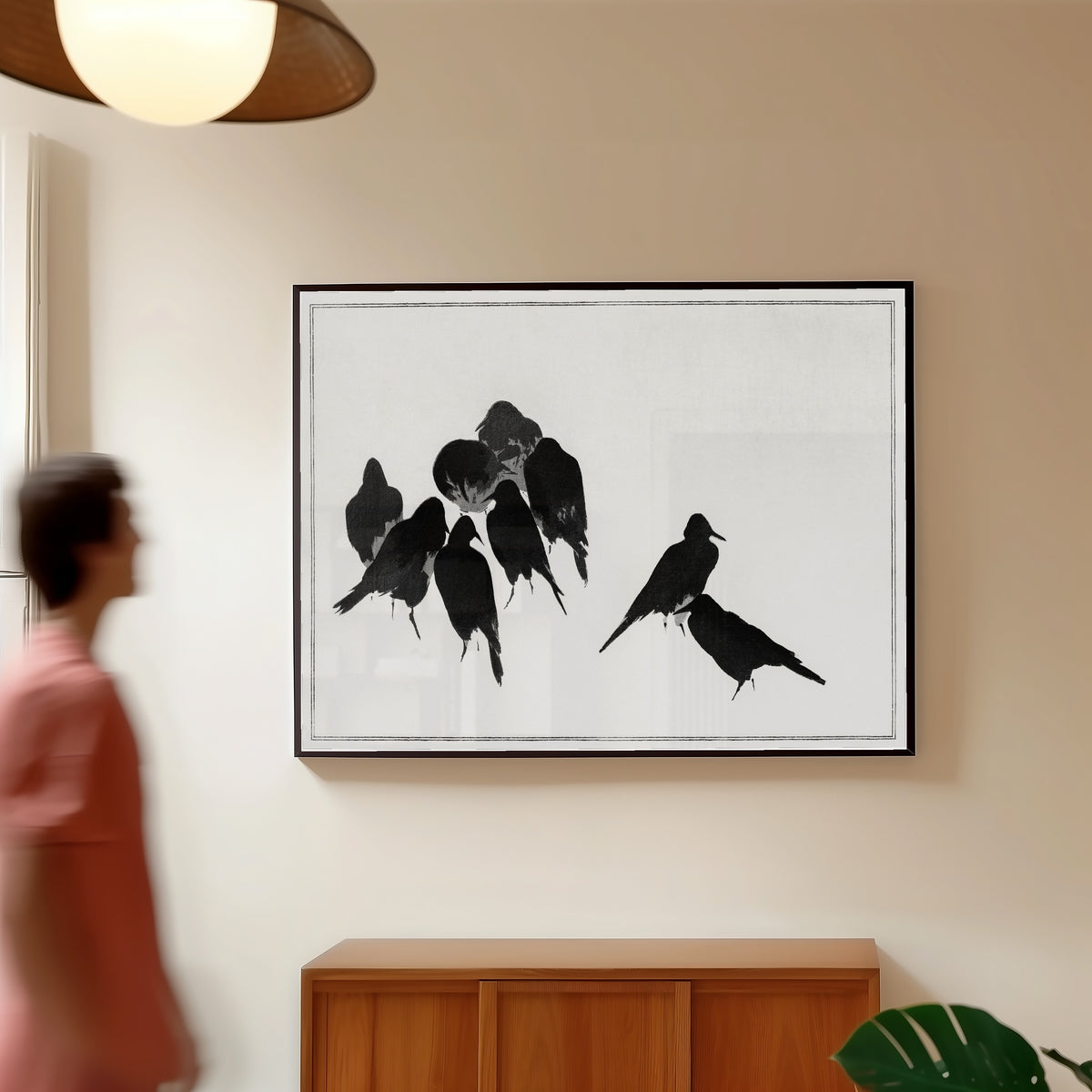 Framed art print of Japanese Crows by Watanabe Seitei, in a slim black frame on a warm wall in a sunlit room