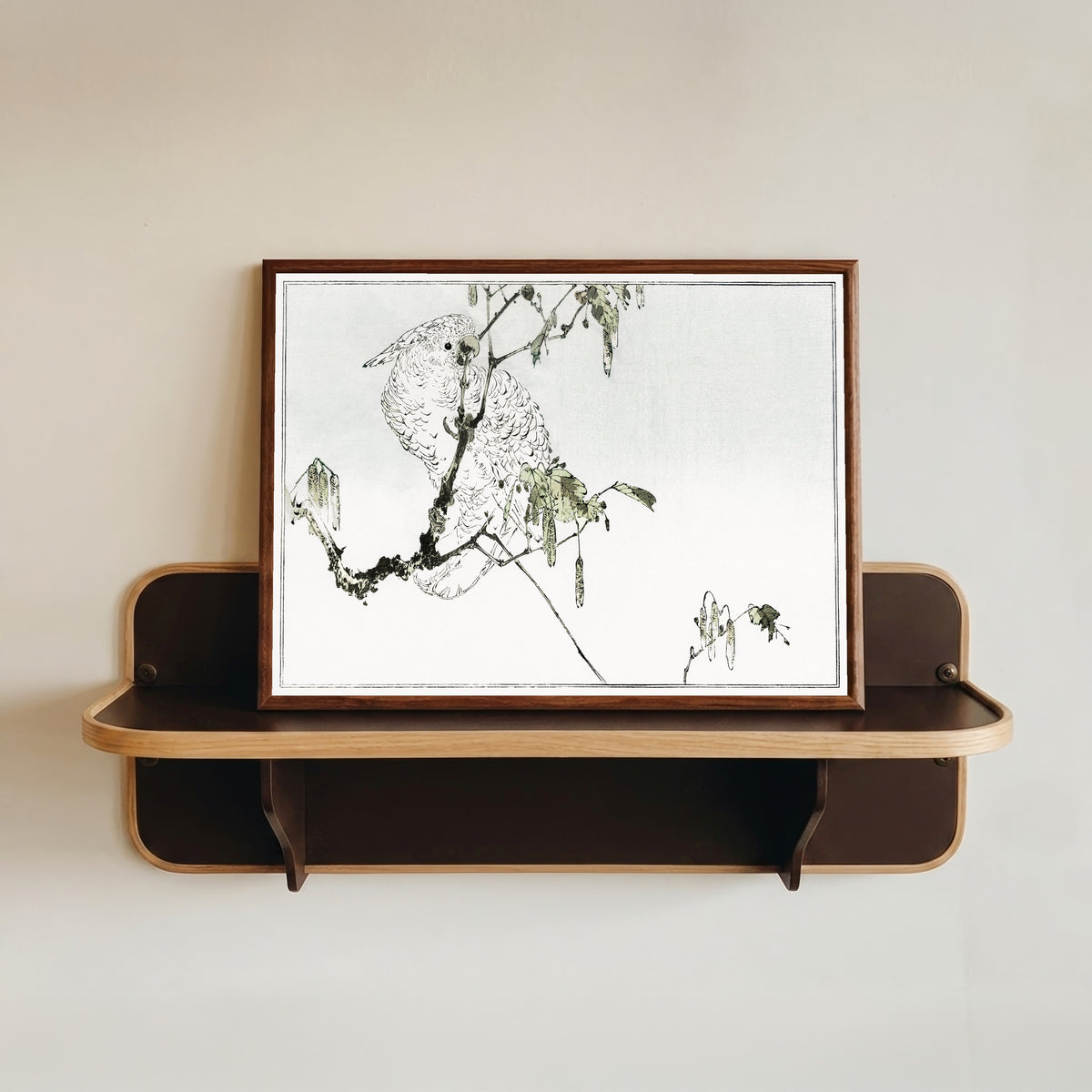 Framed art print of White cockatoo perched on a branch by Watanabe Seitei, in a dark wood frame resting on a wall shelf