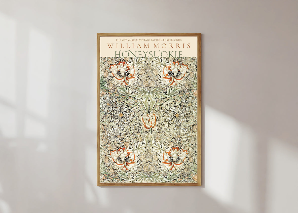 Framed art print of Honeysuckle by William Morris, in a light wood frame on a sunlit white wall