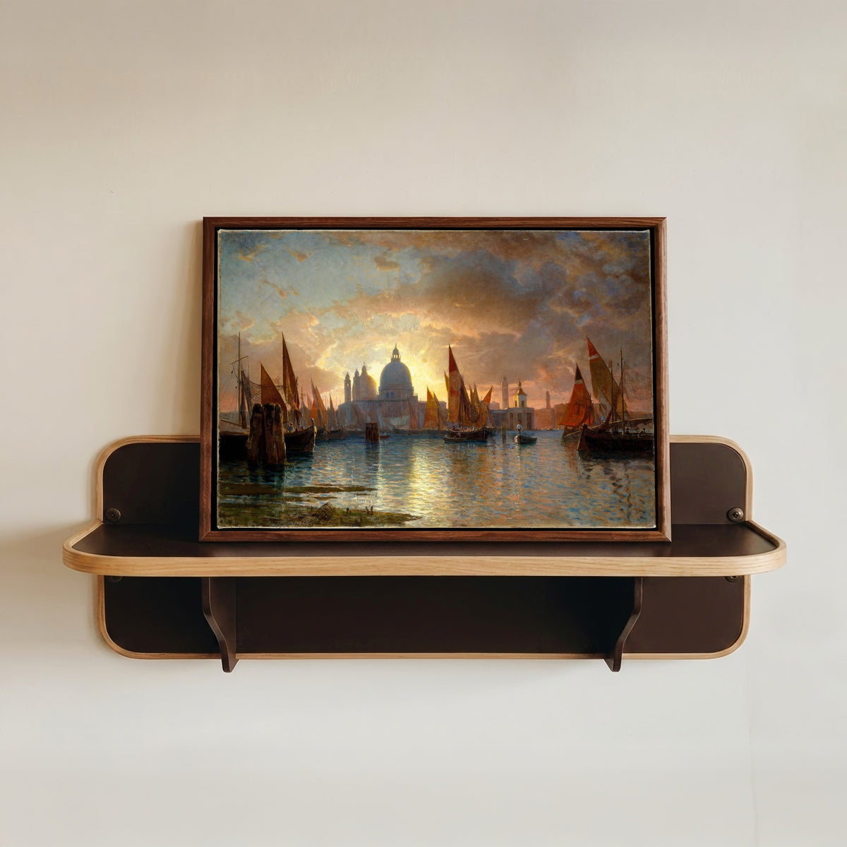 Framed art print of Santa Maria della Salute Sunset Seascape by William Stanley Haseltine, in a dark wood frame resting on a wall shelf