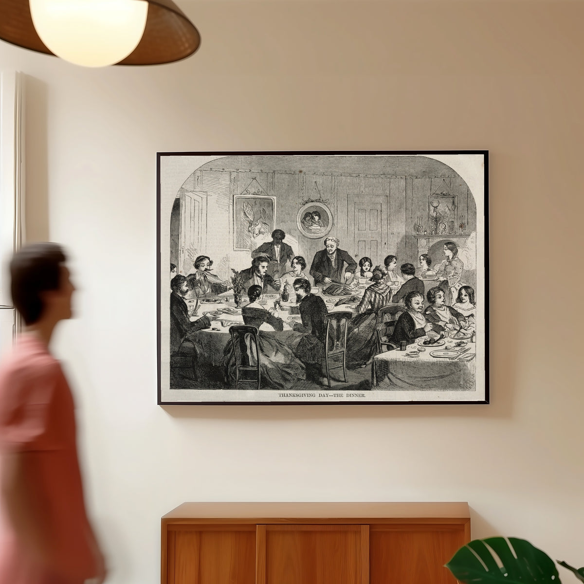Framed art print of Thanksgiving Day – The Dinner by Winslow Homer, in a slim black frame on a warm wall in a sunlit room