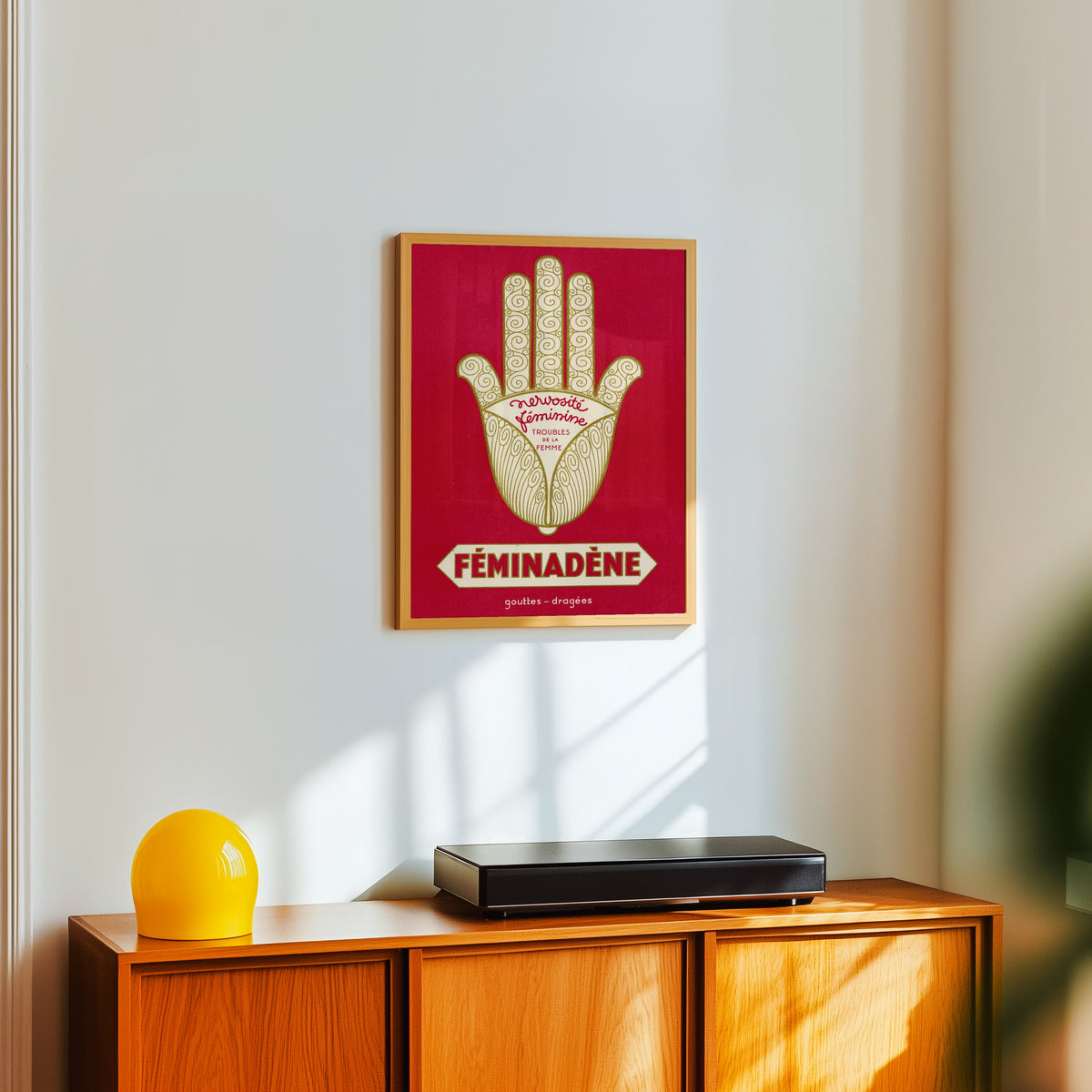 Framed art print of Vintage French Pharmaceutical Poster Print in Red, in a light wood frame on a white wall above an orange sideboard